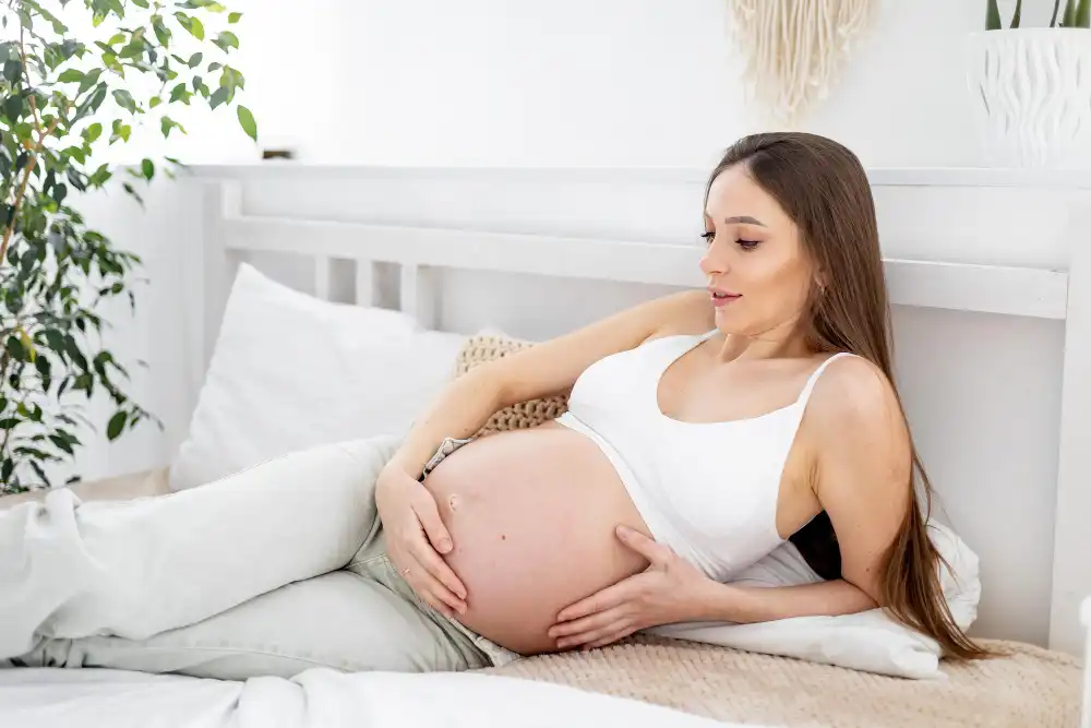 אישה בהריון משתמשת בכרית מיוחדת להריון